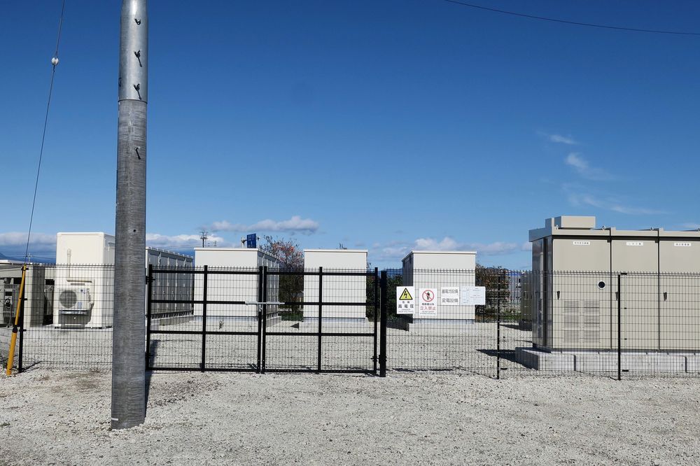 Outdoor battery storage cabinets installed behind a security fence