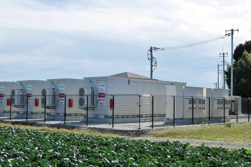 A row of outdoor battery storage cabinets on a prepared site