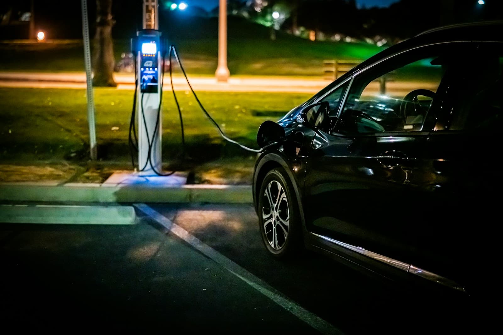 Electric car charging from a kerbside unit on a quiet street at night